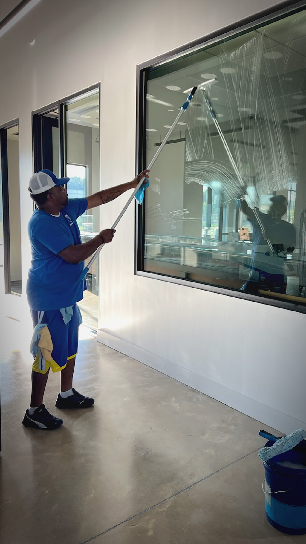 A man washing windows in an office building.